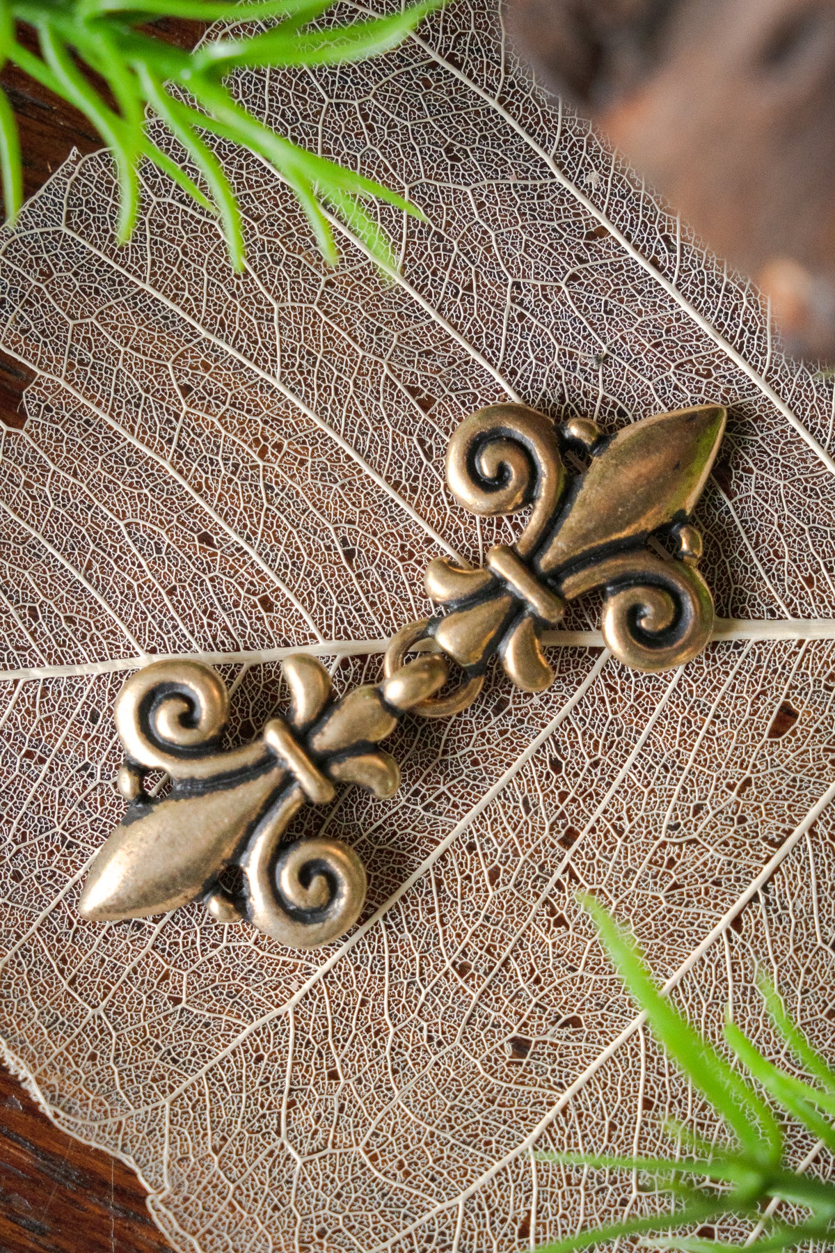 Mantelspänne fleur de lys, brons