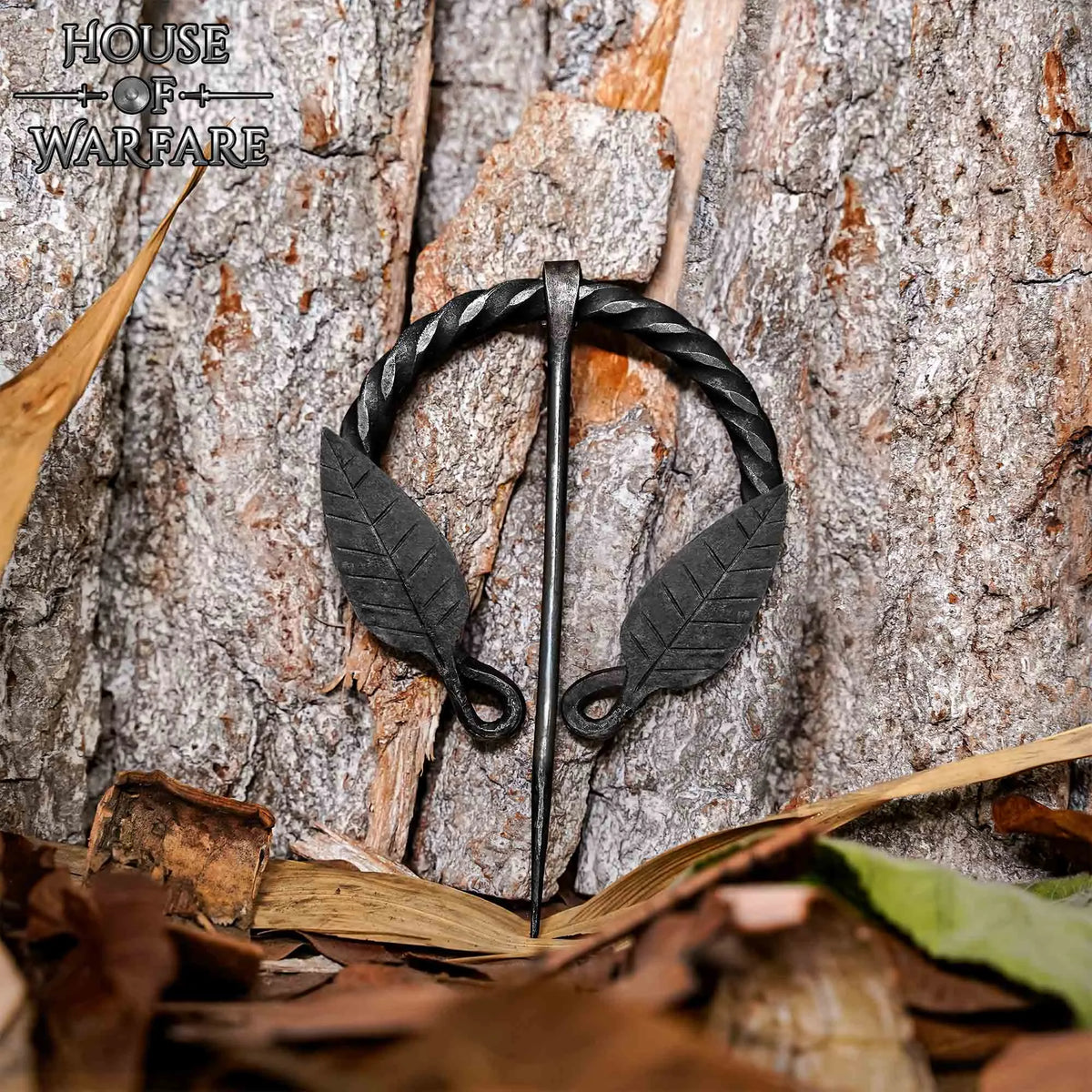 Fibula a ferro di cavallo ritorta con motivo a foglia, ferro