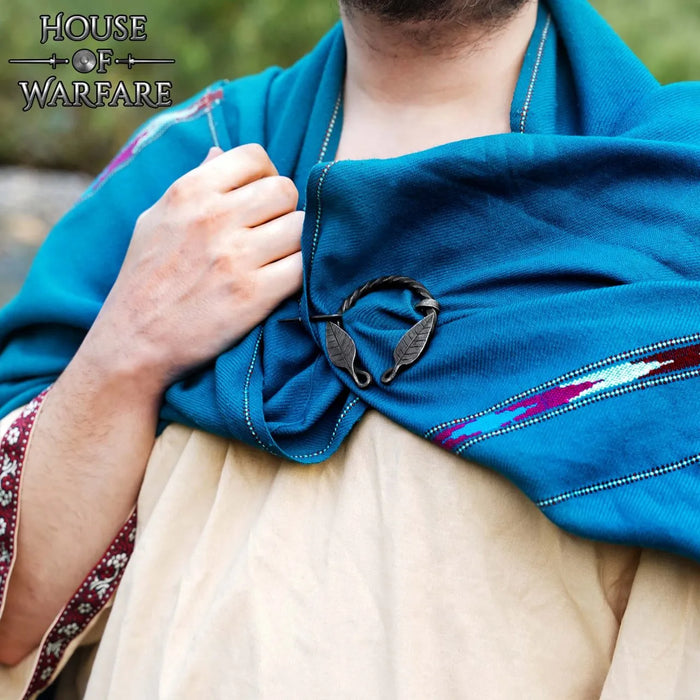 Fibula a ferro di cavallo ritorta con motivo a foglia, ferro