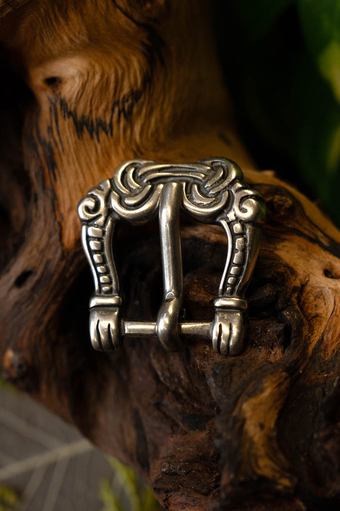 Viking buckle gripping hands, silvered